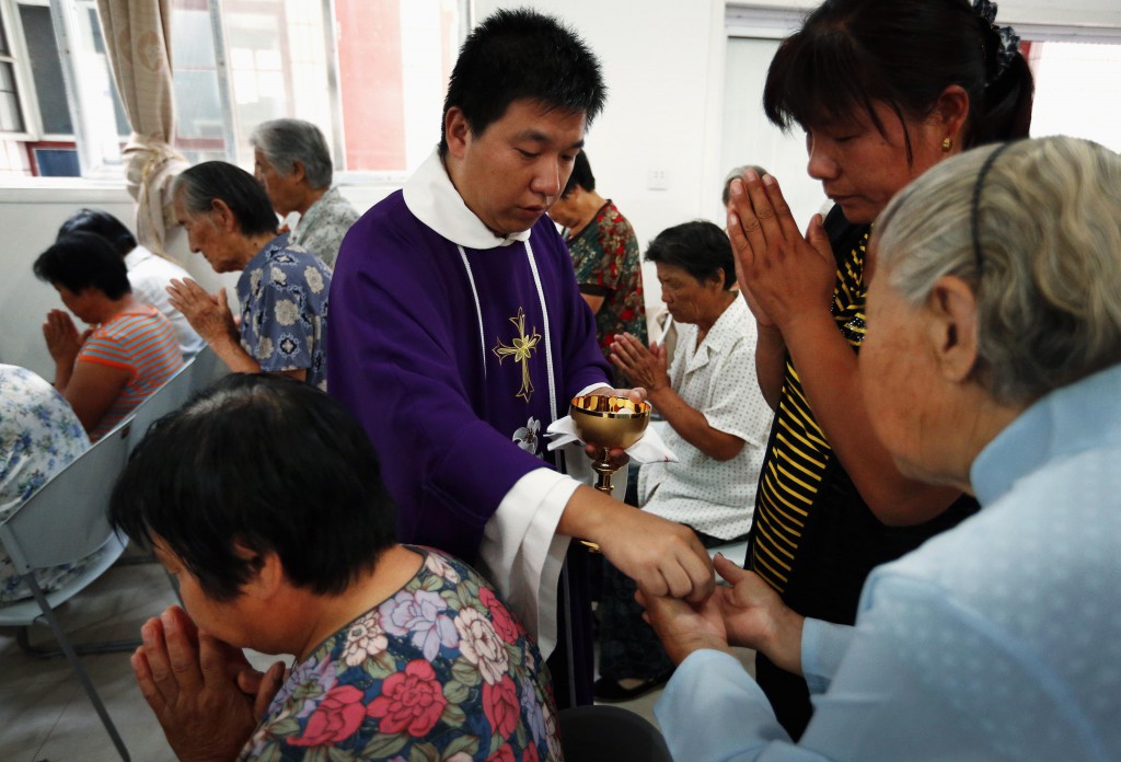 Chinese Father Liu Yong Wang distributes Communion to Catholics in a makeshift chapel in the village of Bai Gu Tun, located about 43 miles southeast of Beijing