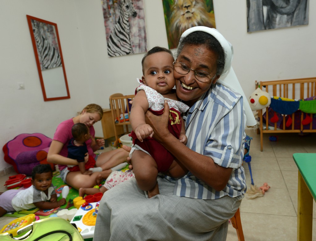 Comboni Sister Azezet Kidane (Sister Aziza) hugs a child at the nursery school in the African Refugee Development Centre’s shelter in Tel Aviv, Israel.