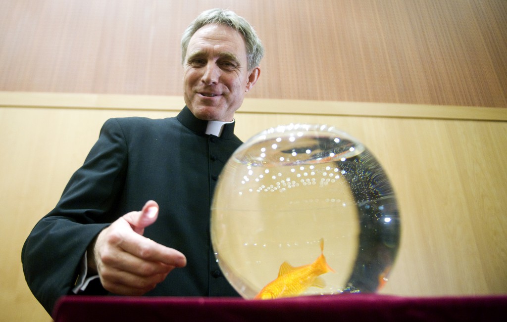 Archbishop-designate Georg Ganswein, personal secretary of Pope Benedict XVI and prefect of the papal household, stands next to a fish bowl on December 11 during the presentation of the Italian-language children's book "The Mystery of a Little Pond" in Rome.