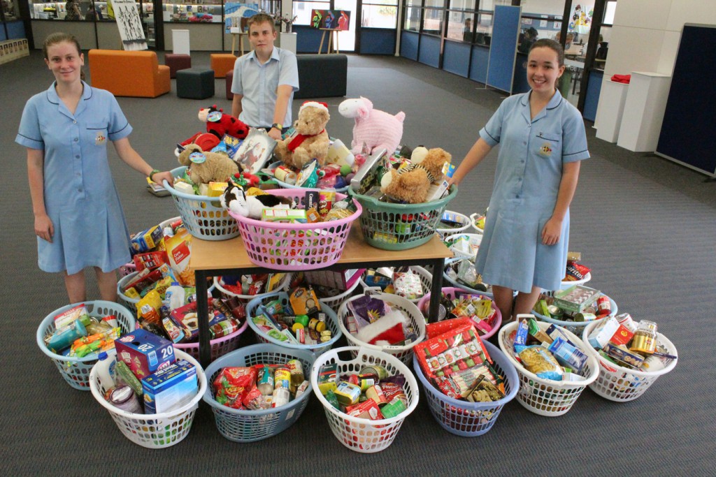 Rockingham students, christine, conner and skye, with the hampers they assembled.