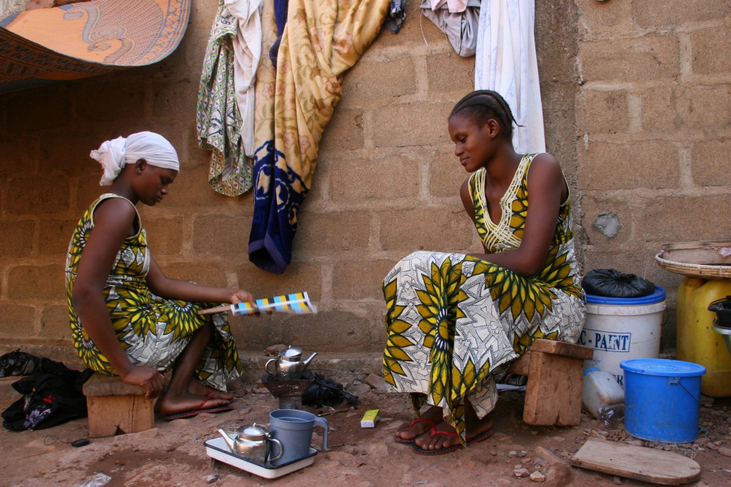 Twins Hawa and Adama Keita, 15, warm a pot of tea in late November outside an area to which 15 other family members have migrated since a March 2012 military coup in Mali. PHOTO: CNS/Helen Blakesley