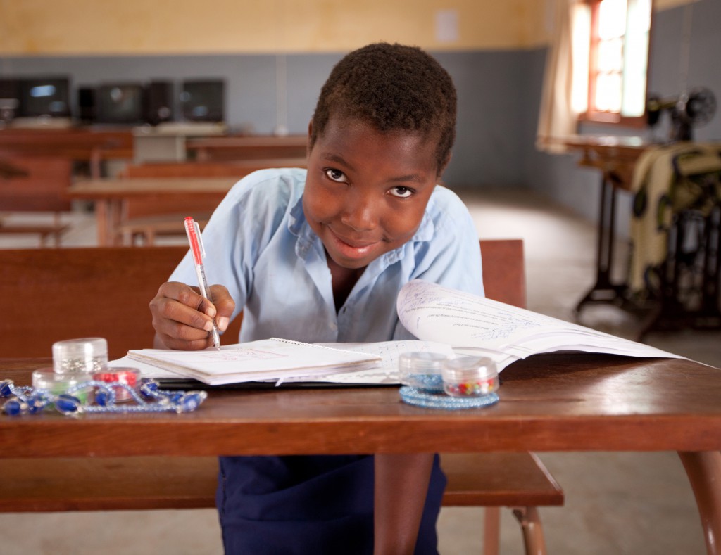 Ditosa Souza Sitoe 12 years, writing in the common room in the community centre in Matuba, Mozambique. PHOTO: Erin Johnson, Caritas Australia.