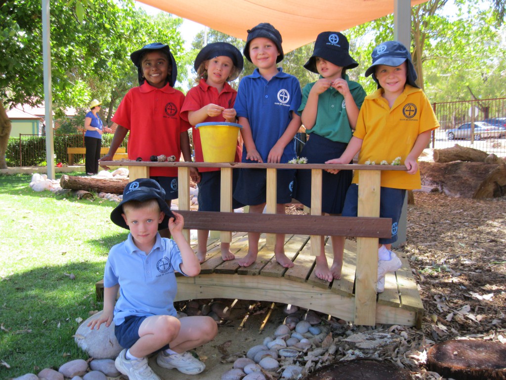 Good Shepherd’s pre-primary and kindergarten students man the pump and hold the bridge in their new nature playground. PHOTO: Peter Rosengren