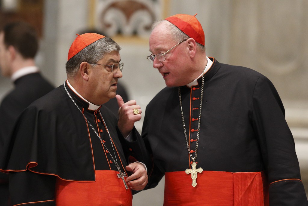 Cardinals Crescenzio Sepe of Naples, Italy, and Timothy M. Dolan of New York talk as they arrive for a prayer service with eucharistic adoration in St. Peter's Basilica at the Vatican on March 6 where more than 100 cardinals gathered in front of Bernini's statue, "The Chair of St. Peter," for the evening service. PHTOT: CNS/Paul Haring