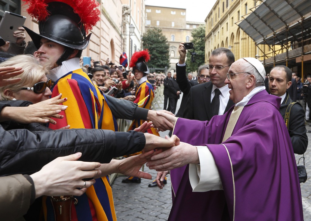 Pope Francis greets people after celebrating Mass at St. Anne's Parish within the Vatican March 17. The new pope greeted every person leaving the small church and then walked over to meet people waiting around St. Anne's Gate. PHOTO: CNS/Paul Haring