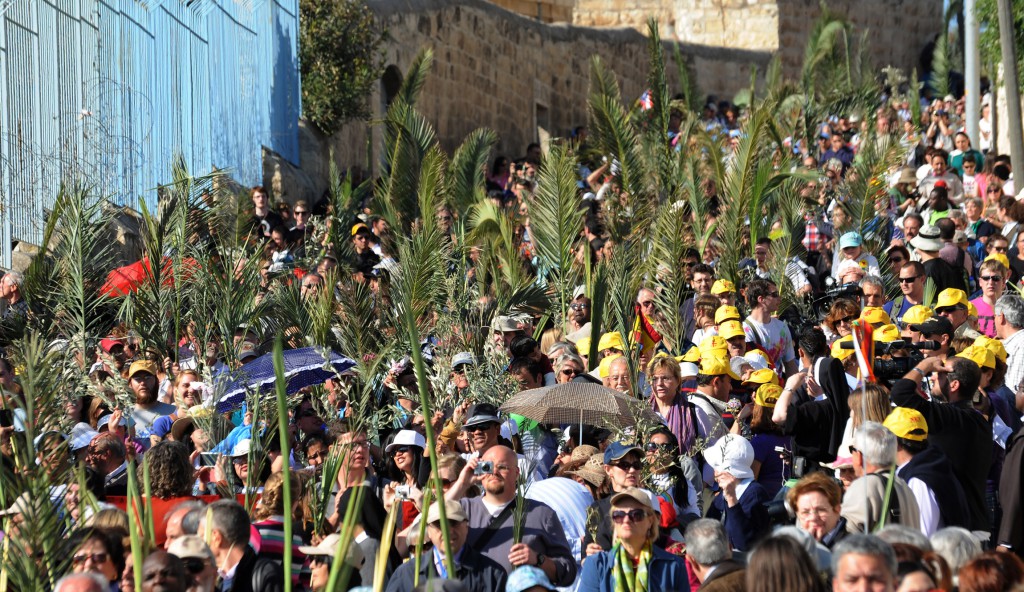 Christian pilgrims carry palm branches during the traditional Palm Sunday procession on March 24 on the Mount of Olives overlooking the Old City of Jerusalem. PHOTO: CNS/Debbie Hill