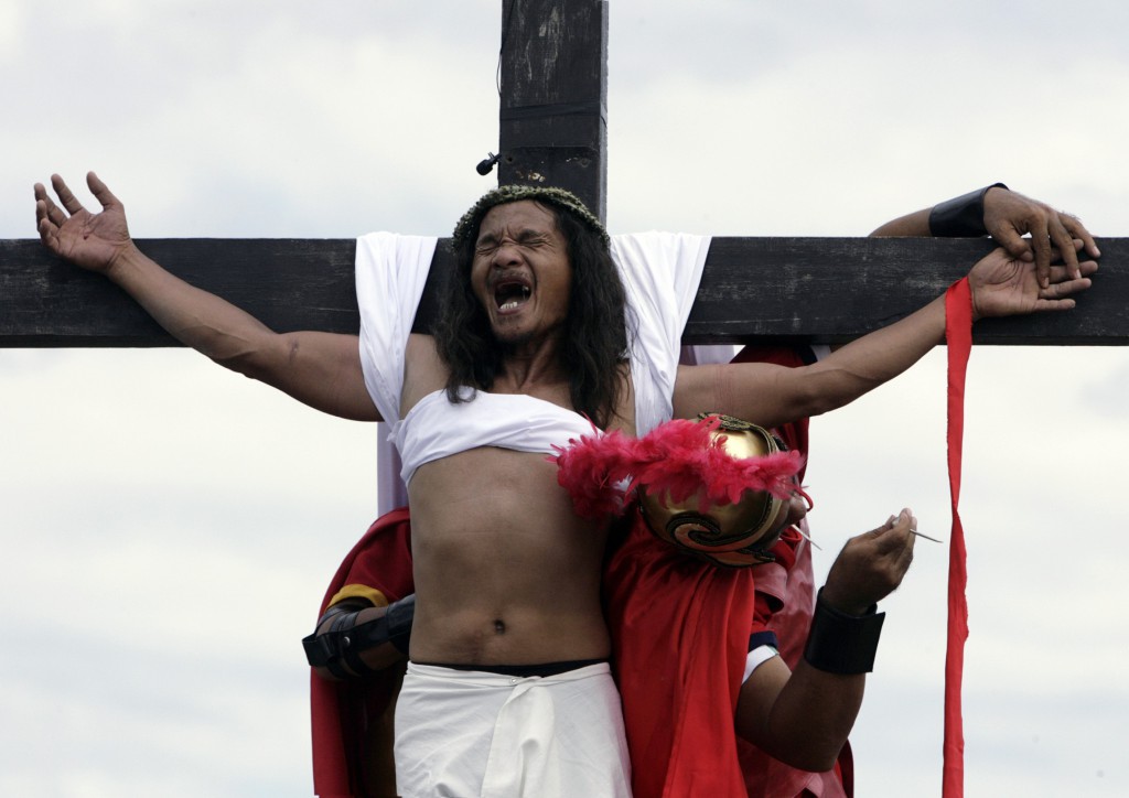 A penitent reacts as nails are removed from his palms after being nailed on a wooden cross in a 2009 Good Friday ritual near Manila, Philippines. PHOTO: CNS/John Javellana, Reuters