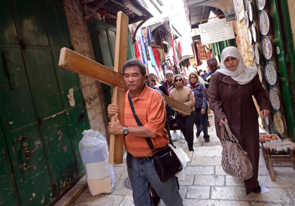 Pilgrims from the Dominican Republic on March 27 carry a cross on the Via Dolorosa, Way of the Cross, the path tradition holds that Jesus followed on the way to his crucifixion in the Old City of Jerusalem. PHOTO: CNS/Debbie Hill