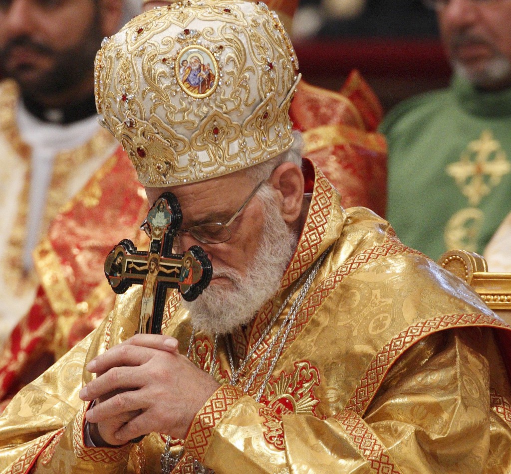 Melkite Patriarch Gregoire III Laham of Damascus, Syria, holds a crucifix as he prays during the closing of Mass. The Syrian patriarch said 'Unless western nations immediately find ways to bring peace to Syria instead of debating whether to arm opposition forces, the country will continue to be in turmoil and a victim of the West's indecision'. PHOTO: CNS/Paul Haring