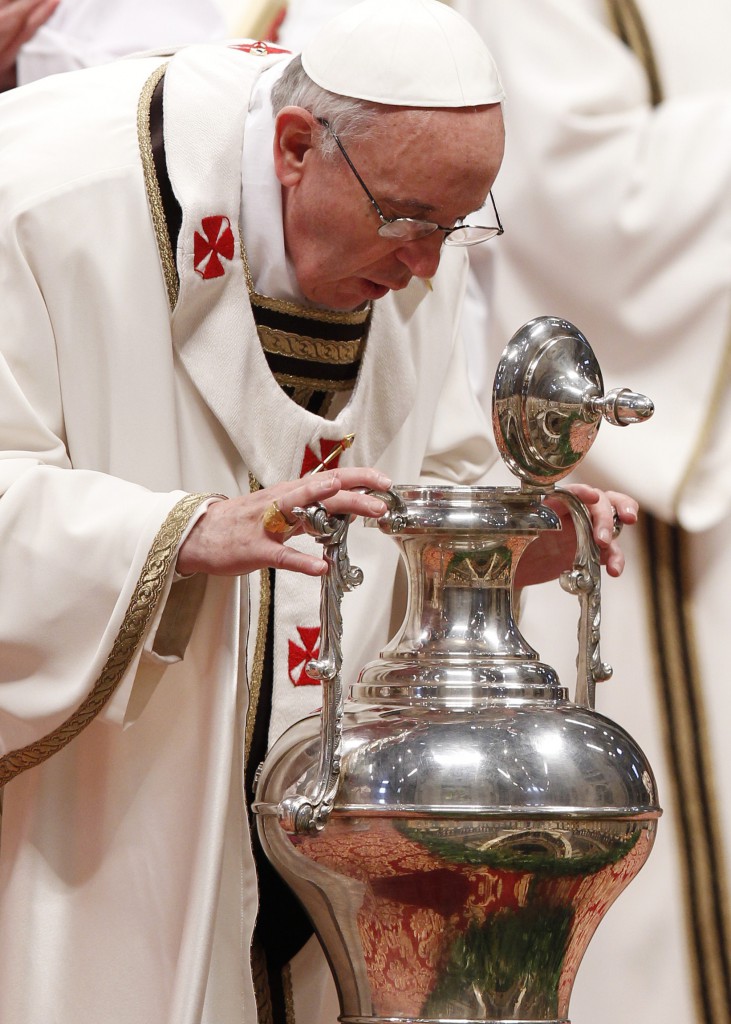 Pope Francis breathes over chrism oil, a gesture symbolizing the infusion of the Holy Spirit, during the Holy Thursday chrism Mass in St. Peter's Basilica on March 28 at the Vatican. PHOTO: CNS/Paul Haring