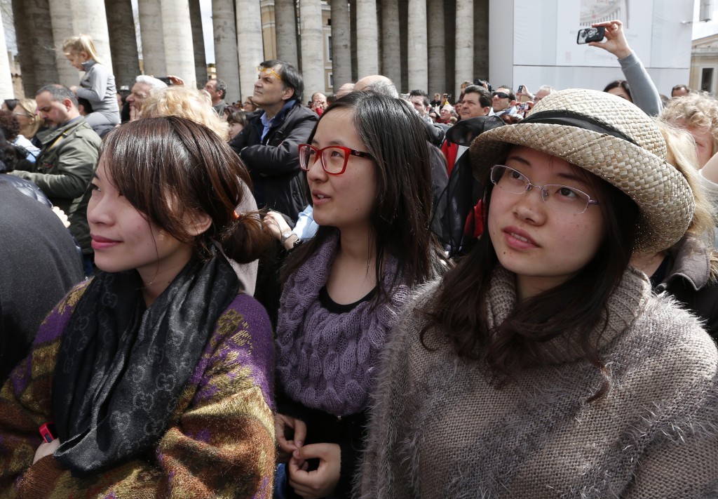 Tourists from China watch as Pope Francis on April 1 leads the "Regina Coeli" (Queen of Heaven) prayer from the window of the papal apartment overlooking St. Peter's Square at the Vatican. PHOTO: CNS/Paul Haring