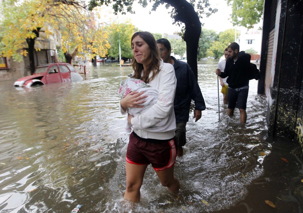 People wade through a flooded street after a rainstorm in Buenos Aires, Argentina, April 2. Affirming his closeness to his "beloved Argentine people," Pope Francis offered his prayers for the victims of recent flooding in Buenos Aires and surrounding areas, and he urged government offices and private citizens to help those most in need. PHOTO: CNS/Enrique Marcarian, Reuters
