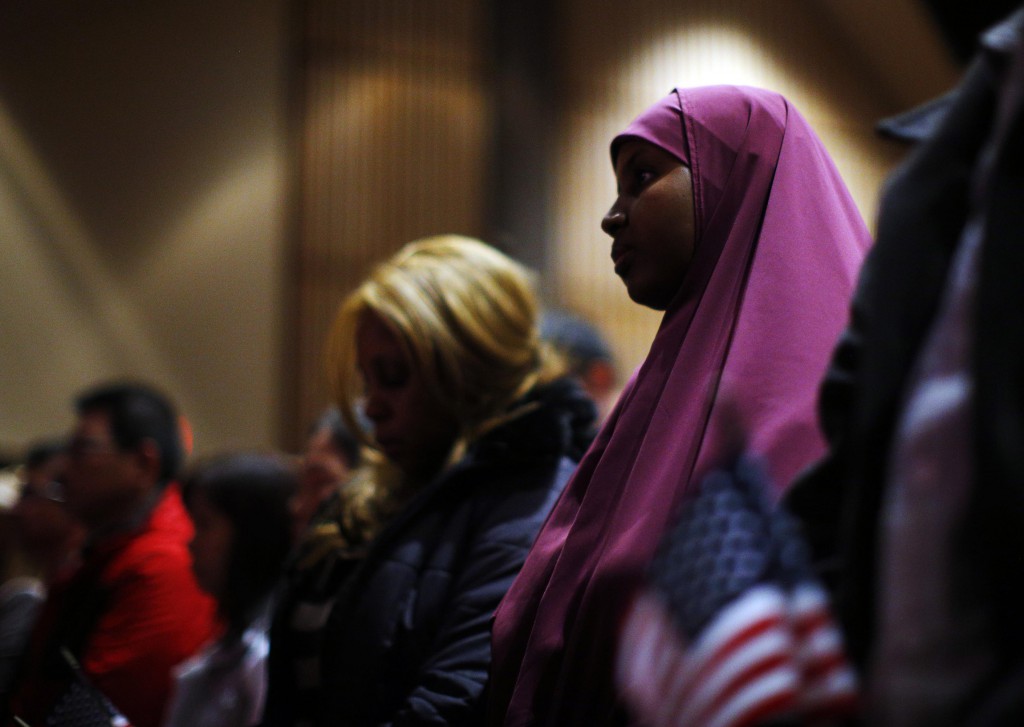 Immigrants stand during a naturalization ceremony to become U.S. citizens in late March at Boston College in Chestnut Hill, Mass. As the U.S. Senate returns after break and tens of thousands plan a rally, Washington lawmakers focus on immigration reform. PHOTO: CNS/Brian Snyder, Reuters