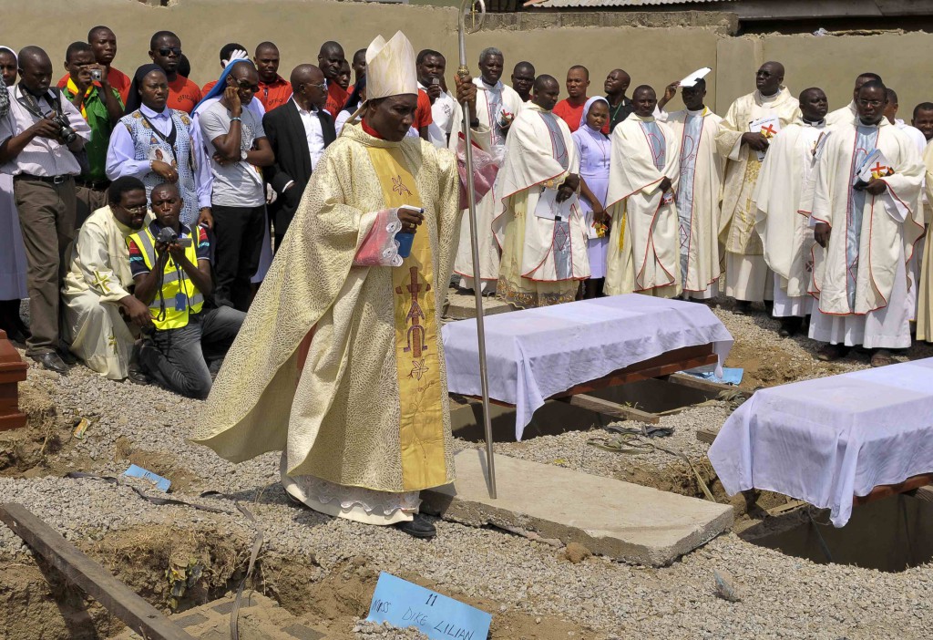 Bishop Martin Igwemezie Uzoukwu of Minna, Nigeria, walks near the coffins of some of the victims of a 2012 Christmas bombing at St. Theresa Catholic Church in Madalla, Nigeria, during a funeral for the victims. PHOTO: CNS/Afolabi Sotunde, Reuters