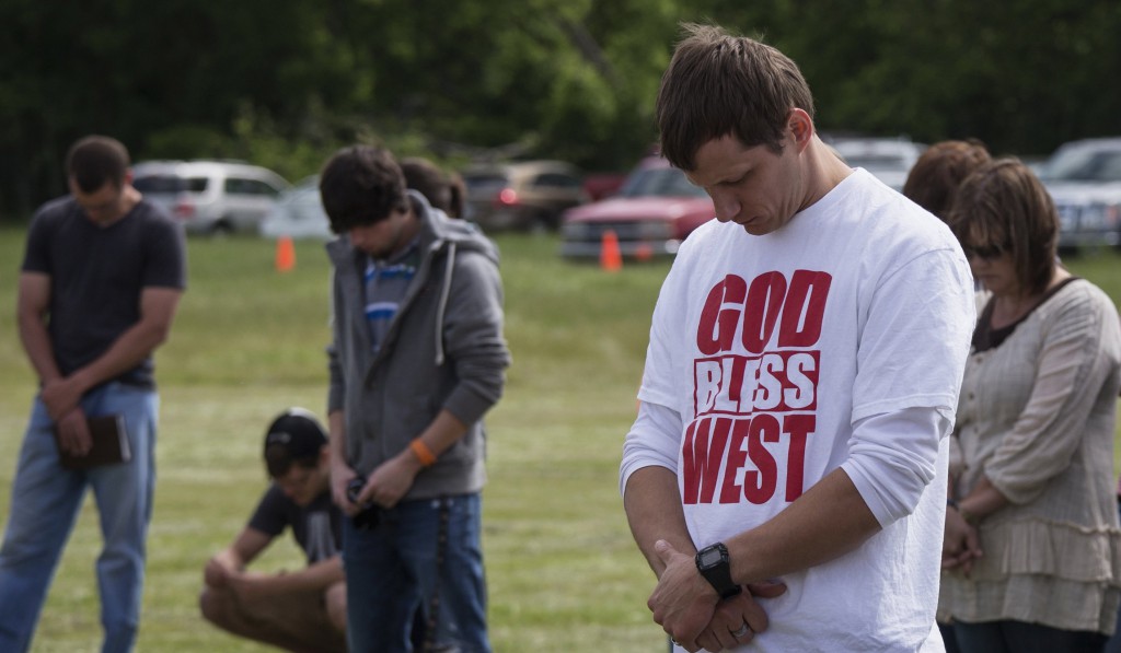 Town residents bow their heads in prayer during an April 21 outdoor prayer service four days after a deadly fertilizer plant explosion in the town of West, near Waco, Texas. PHOTO: CNS/Adrees Latif, Reuters
