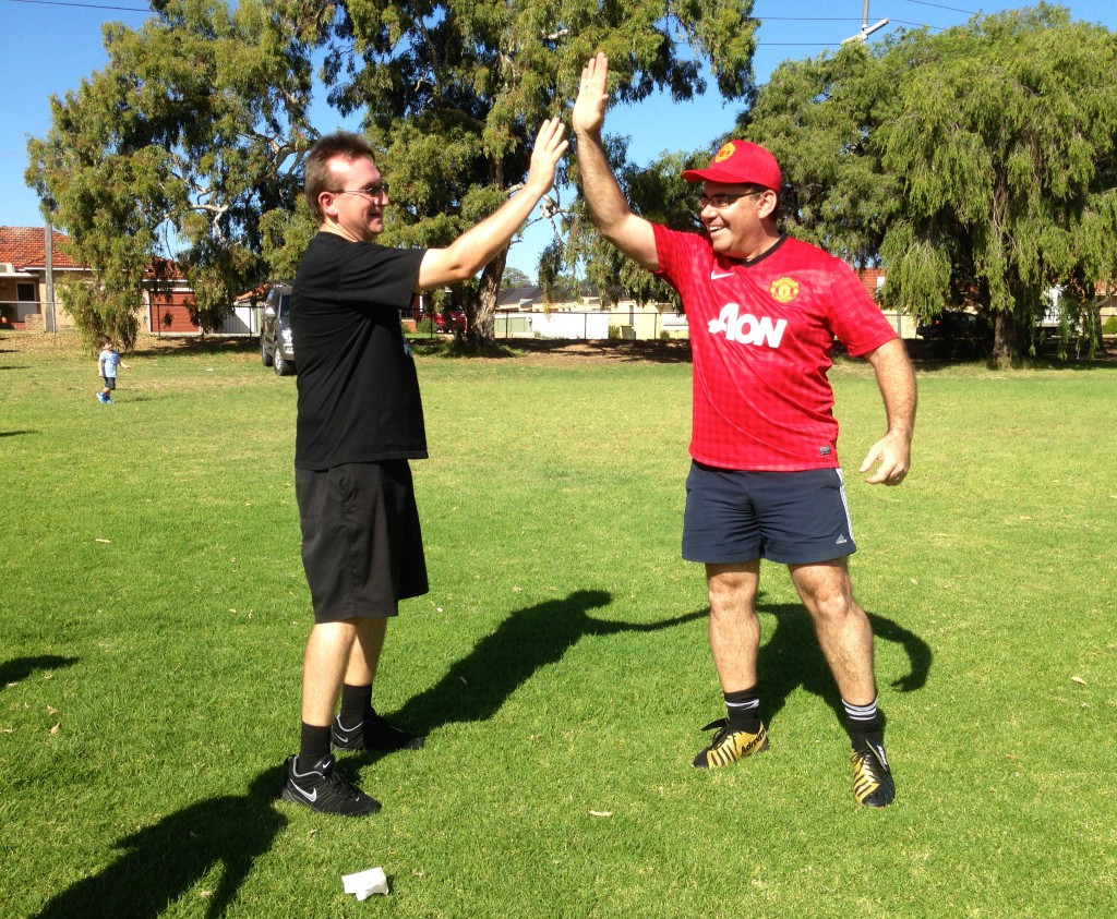 Balcatta Parish Priest Fr Irek Czech SDS, left, high-fives a fellow participant in the parish’s sports day held on April 7. Participants competed in golf and soccer.