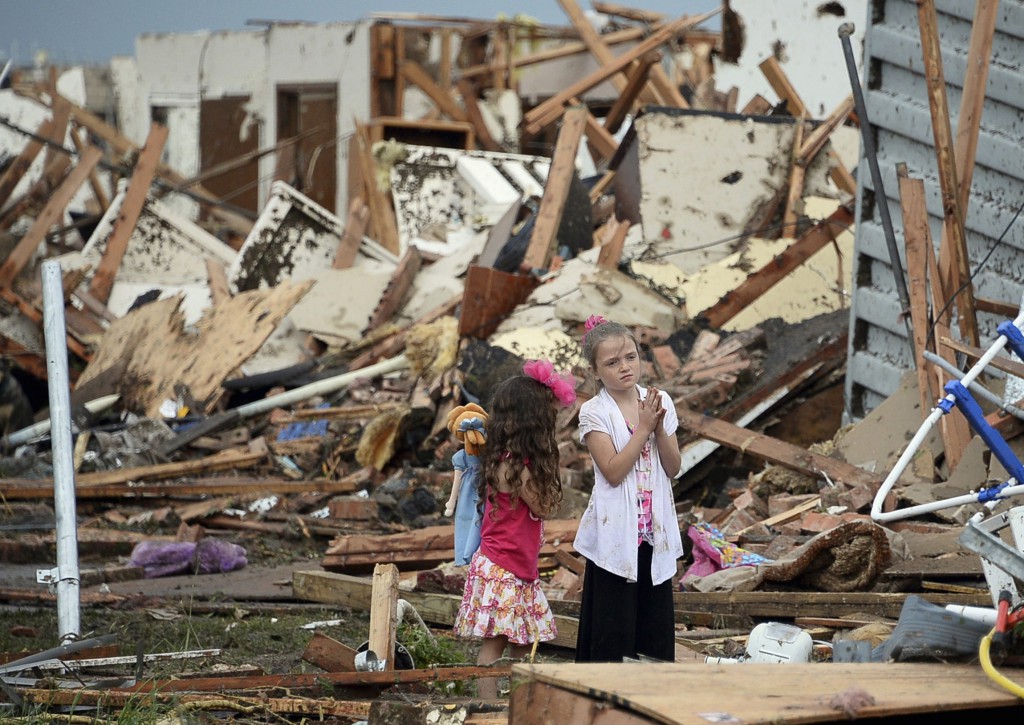 Two girls stand in rubble after a tornado struck Moore, Okla., May 20. The mile-wide tornado touched down near Oklahoma City, killing dozens, including many children, destroying homes, businesses and a pair of elementary schools in the suburb of  Moore. PHOTO: CNS/Gene Blevins, Reuters