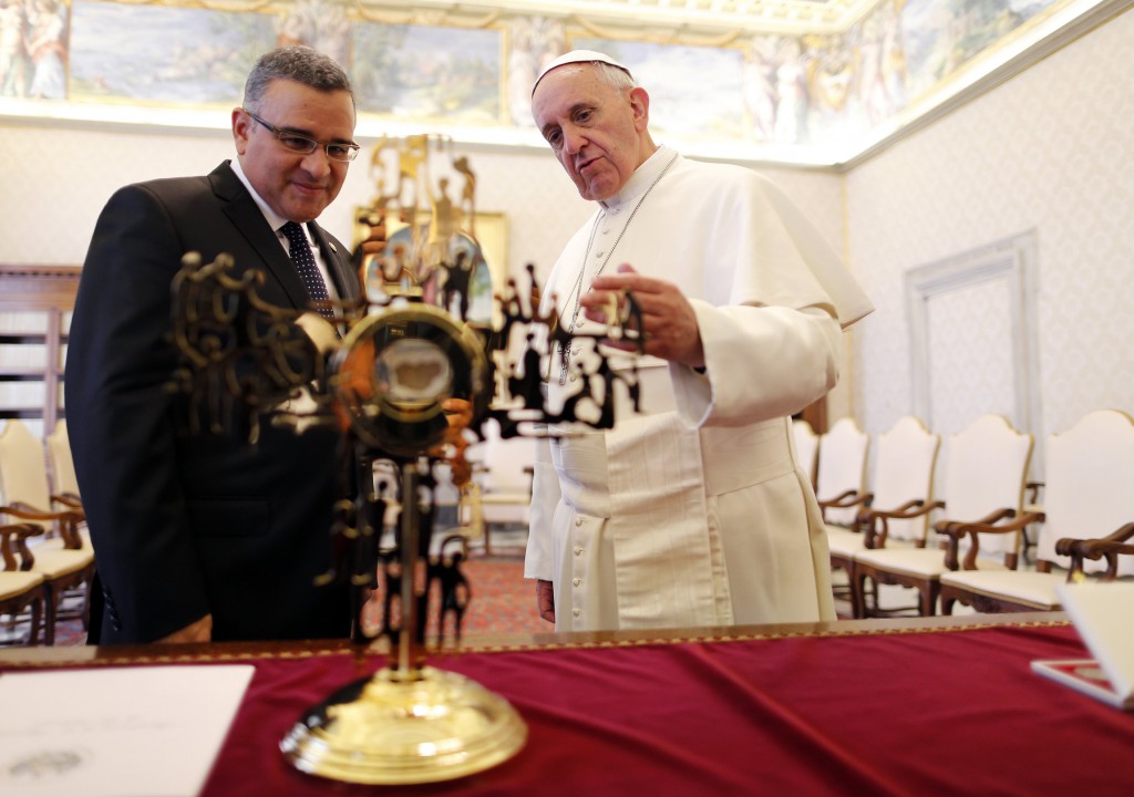 Pope Francis and President Mauricio Funes Cartagena of El Salvador look at a reliquary containing a blood-stained piece of the vestment of Archbishop Oscar Romero during a private audience in the Apostolic Palace on May 23 at the Vatican. 