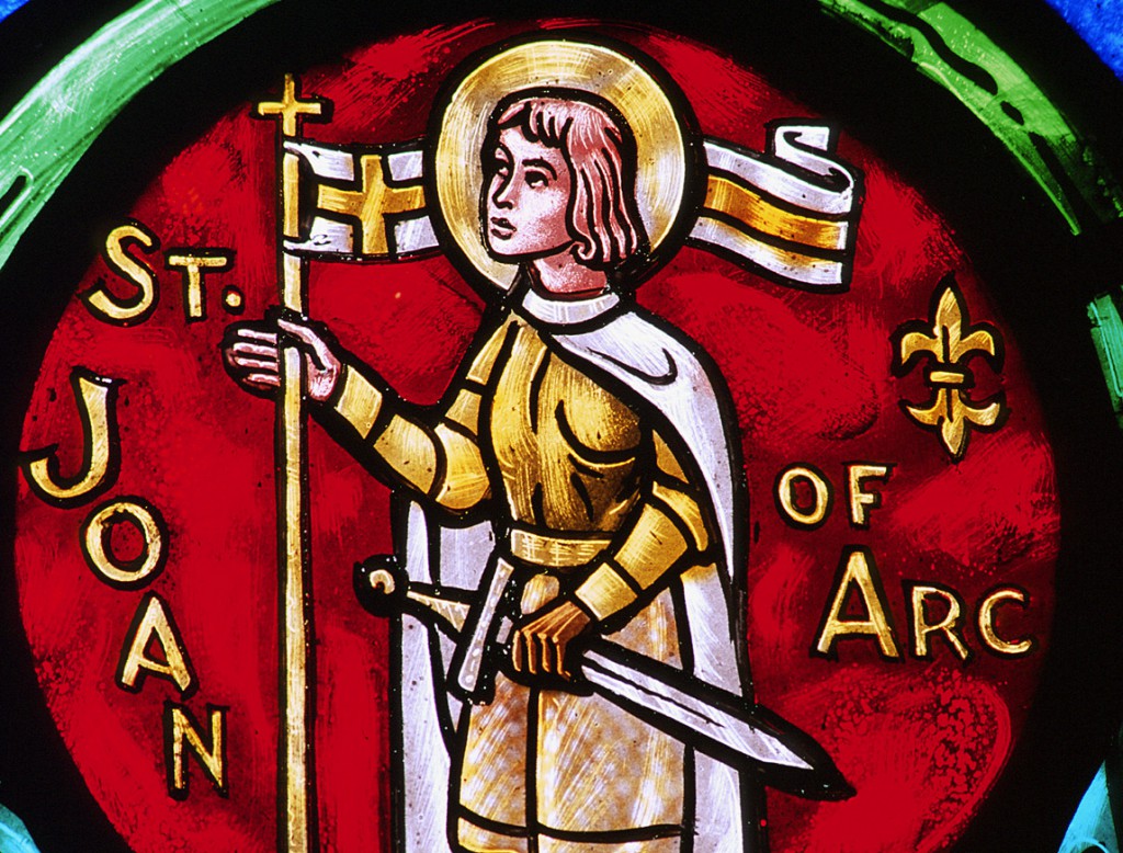A church window depicts St. Joan of Arc with a sword. The French peasant girl was inspired by a series of saintly visions to help save France from the English in the Hundred Years' War. She led the victory at the besieged city of Orleans, but was later captured and burned at the stake. She is patron of France. Her feast is May 30. PHOTO: CNS/Crosiers