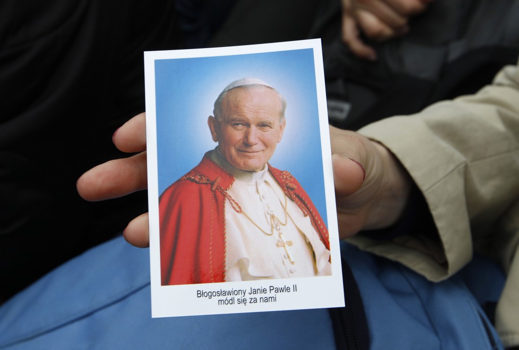A woman holds a prayer card with an image of Blessed John Paul II during an outdoor Mass celebrated in his hometown of Wadowice, Poland, on May 1, the day of his beatification. PHOTO: CNS photo/Peter Andrews, Reuters