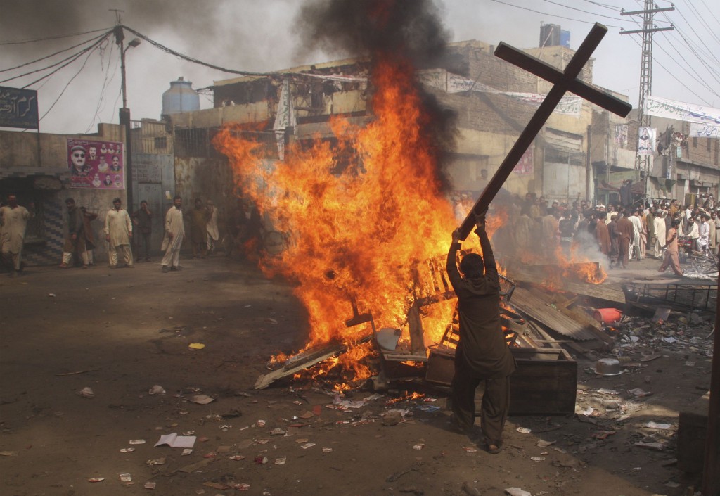 A demonstrator burns a cross during a protest on March 9 in the Badami Bagh area of Lahore, Pakistan. PHOTO: CNS/Adrees Hassain, Reuters