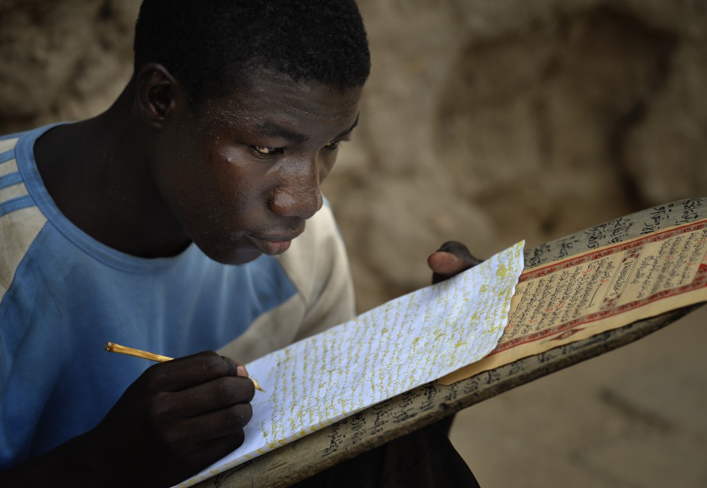 A boy copies Quranic verses in a Muslim school in June in Timbuktu, the northern Mali city that was seized by Islamist fighters in 2012 and then liberated by French and Malian soldiers in early 2013. The people of the ancient city suffered and many fled under the rebel takeover. Now, many have yet to return home as the crisis in the north shows no signs of waning. PHOTO: CNS/Paul Jeffrey