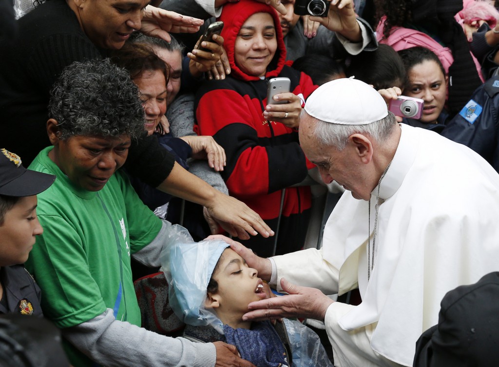 Pope Francis blesses a boy in the Varginha slum in Rio de Janeiro July 25, during his weeklong visit to Brazil for World Youth Day. PHOTO: CNS/Paul Haring