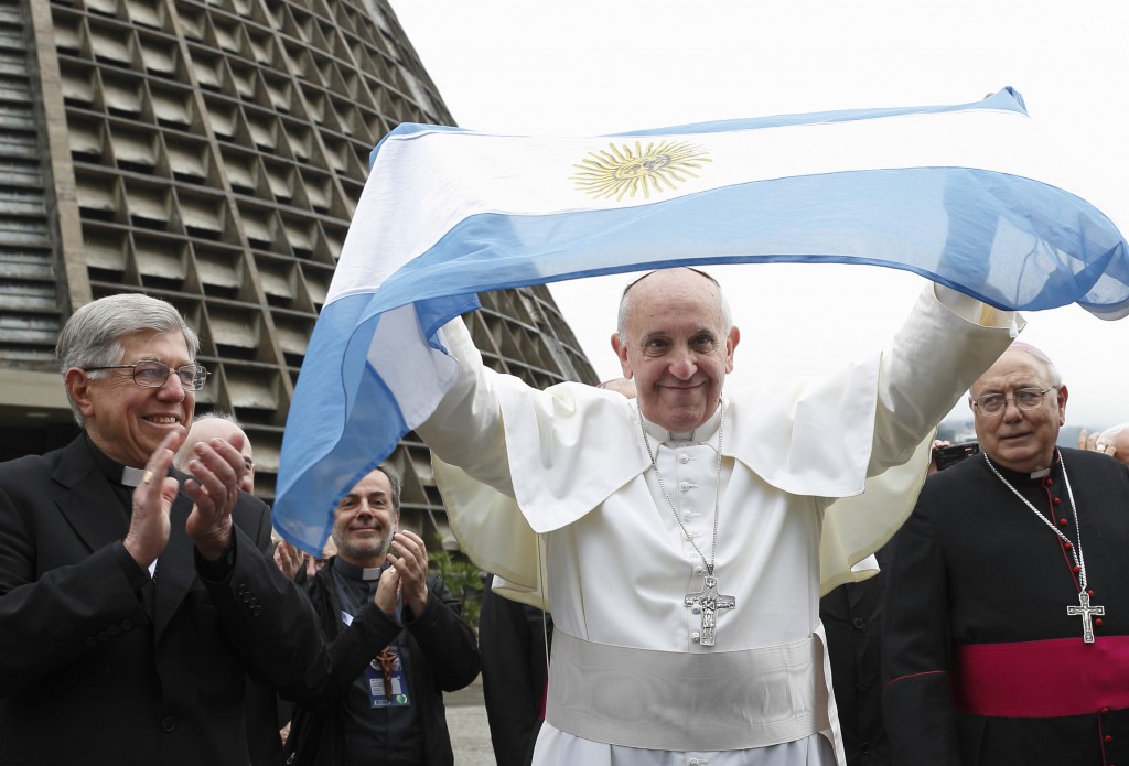Pope Francis holds up Argentina's flag as he greets a crowd of World Youth Day pilgrims on July 25 outside the cathedral in Rio de Janeiro. PHOTO: CNS/Paul Haring