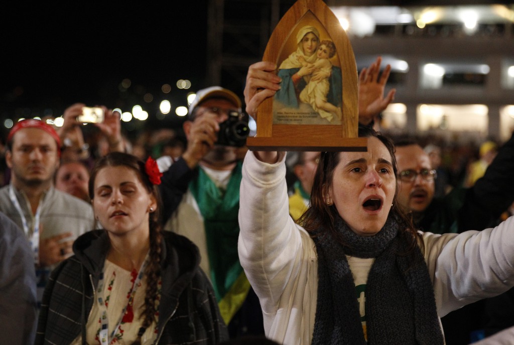 A woman holds an icon during the Eucharistic adoration led by Pope Francis on July 27 at the World Youth Day vigil on Copacabana beach in Rio de Janeiro. PHOTO: CNS/Paul Haring