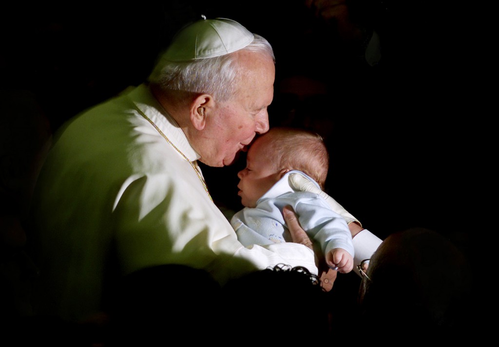 Pope John Paul II kisses a baby on Nov. 28, 2001 during a weekly general audience. PHOTO: CNS/Reuters
