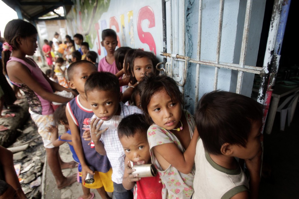 Children living in a squatters' area wait Sept. 21 for a free meal consisting of rice, chicken and vegetables that is given out daily by a South Korean religious missionary organization near Manila, Philippines. PHOTO: CNS/Erik De Castro, Reuters