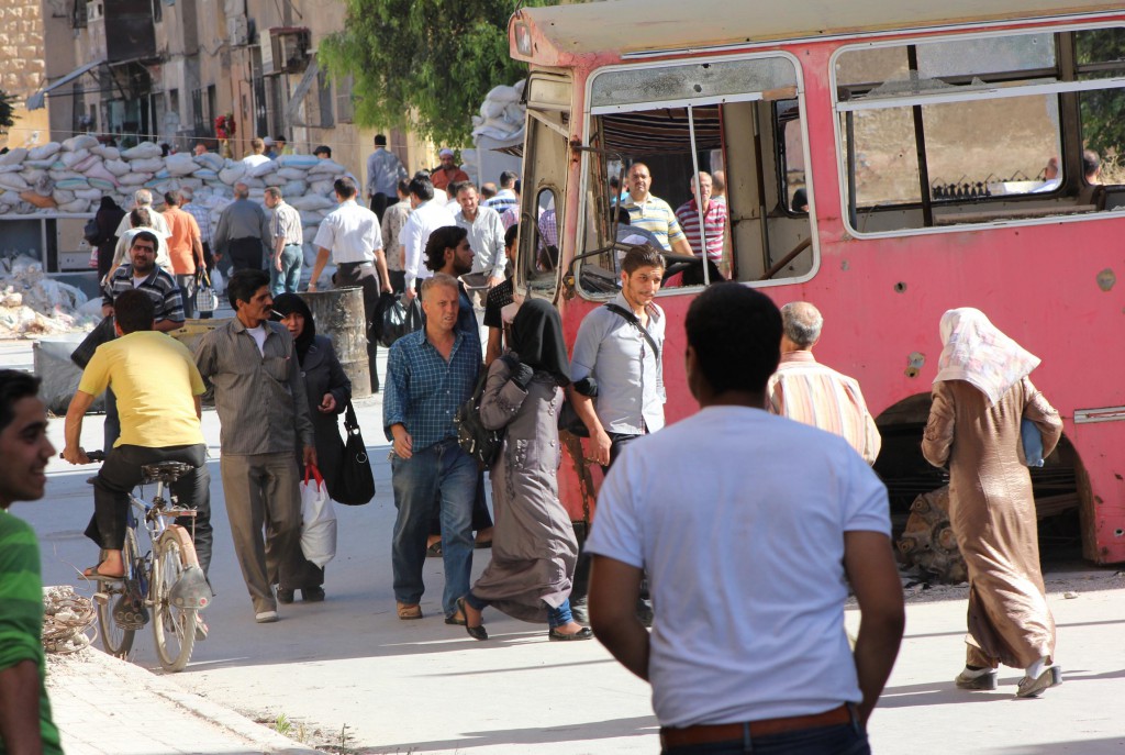 Syrian civilians walk on June 5 along a passageway separating Aleppo's Bustan al-Qasr neighborhood, which is under the rebels' control, and the Al-Masharqa neighborhood, an area controlled by the regime. PHOTO: CNS/Aref Hretani, Reuters