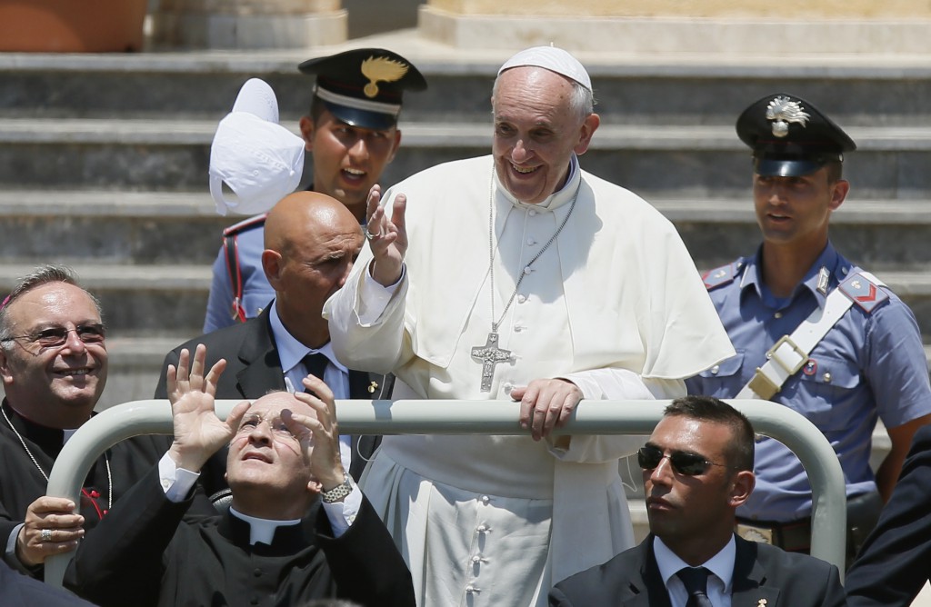 A white baseball cap is thrown toward  Pope Francis as he leaves in a jeep after visiting San Gerlando Parish in Lampedusa, Italy, July 8. Tossing, lobbing and throwing things to the pope or into the pope's vehicles has been a growing phenomenon. This hat was caught by the pope's personal secretary. PHOTO: CNS/Paul Haring