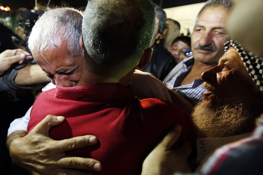 A relative greets a freed Palestinian prisoner (back facing camera) as he arrives in Ramallah, West Bank, early Aug.14. Later that day Palestinians and Israelis were to hold their first formal peace talks in the Mideast in nearly five years. PHOTO: CNS/Mohamad Torokman, Reuters
