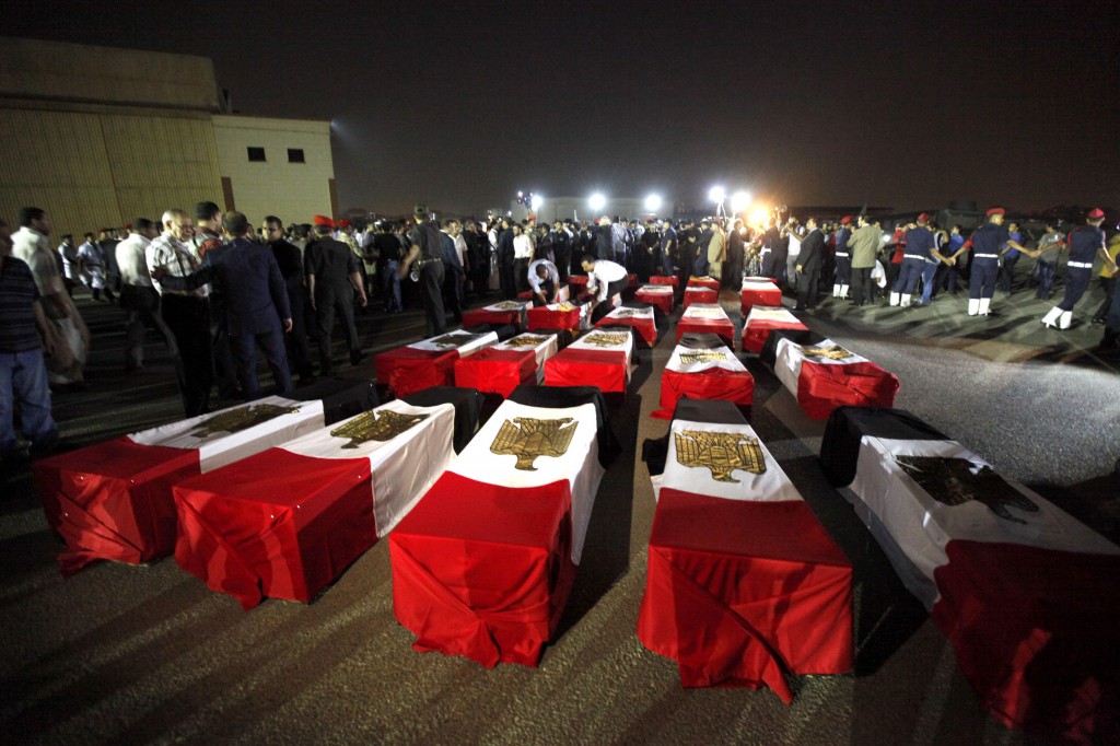 The caskets of 25 policemen killed near the north Sinai town of Rafah lay on the ground after arriving at a military airport in Cairo Aug. 19. The Egyptian policemen were killed and three others wounded in an ambush. Attacks by Islamist militants in the lawless north Sinai region have intensified since the army overthrew President Mohammed Morsi. PHOTO: CNS/Mohamed Abd El Ghany, Reuters