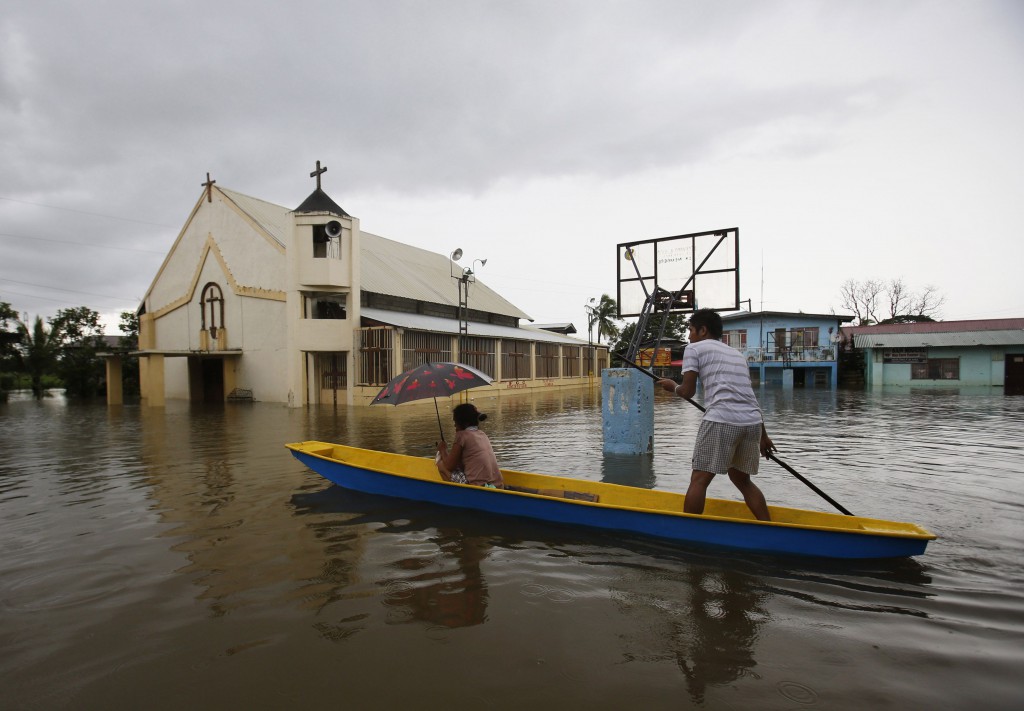 People make their way by boat past a church along a flooded road in Bulacan, Philippines, Aug. 21. Hundreds of thousands of people in metro Manila and surrounding areas have been affected by heavy monsoon rains and flooding. PHOTO: CNS/Erik de Castro, Reuters