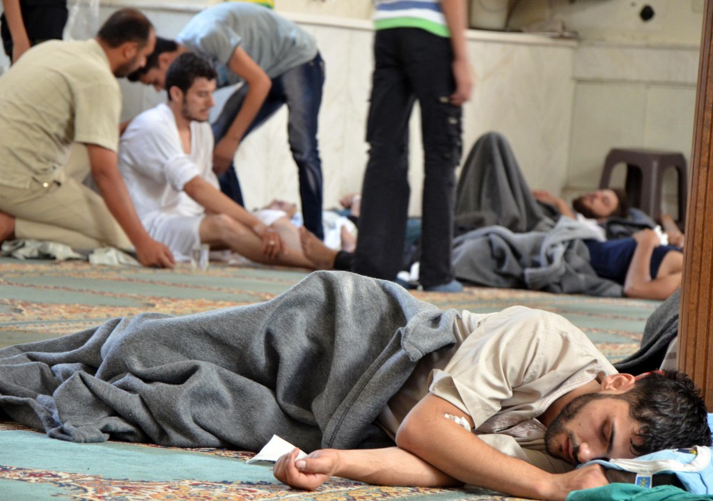 People rest in a mosque ill from what anti-government activists say was a gas attack carried out by Syrian forces in the Duma neighborhood of Damascus Aug. 21. Syrian activists accused President Bashar Assad's forces of launching a gas attack that killed hundreds of people. If confirmed, it would be the worst reported use of chemical arms in the two-year-old civil war. Syrian state television denied government forces had used poison gas and said the accusations were intended to distract a team of United Nations chemical weapons experts that arrived three days ago. PHOTO: CNS/Bassam Khabieh, Reuters