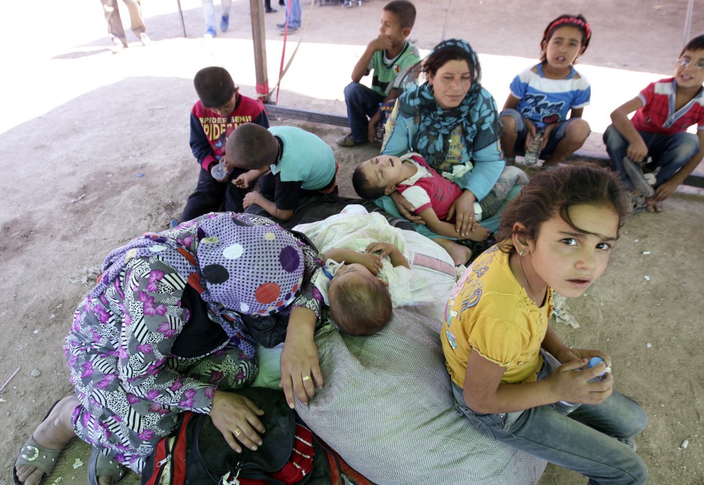 Syrians fleeing violence in their country wait to cross the border into the autonomous Kurdish region of northern Iraq Aug. 25. The sudden influx of more than 40,000 Syrian refugees over the past 10 days has brought Iraq's prosperous and well-armed northern region closer to the Syrian conflict, which has already left more than 100,000 people killed and displaced millions. PHOTO: CNS/Azad Lashkari, Reuters