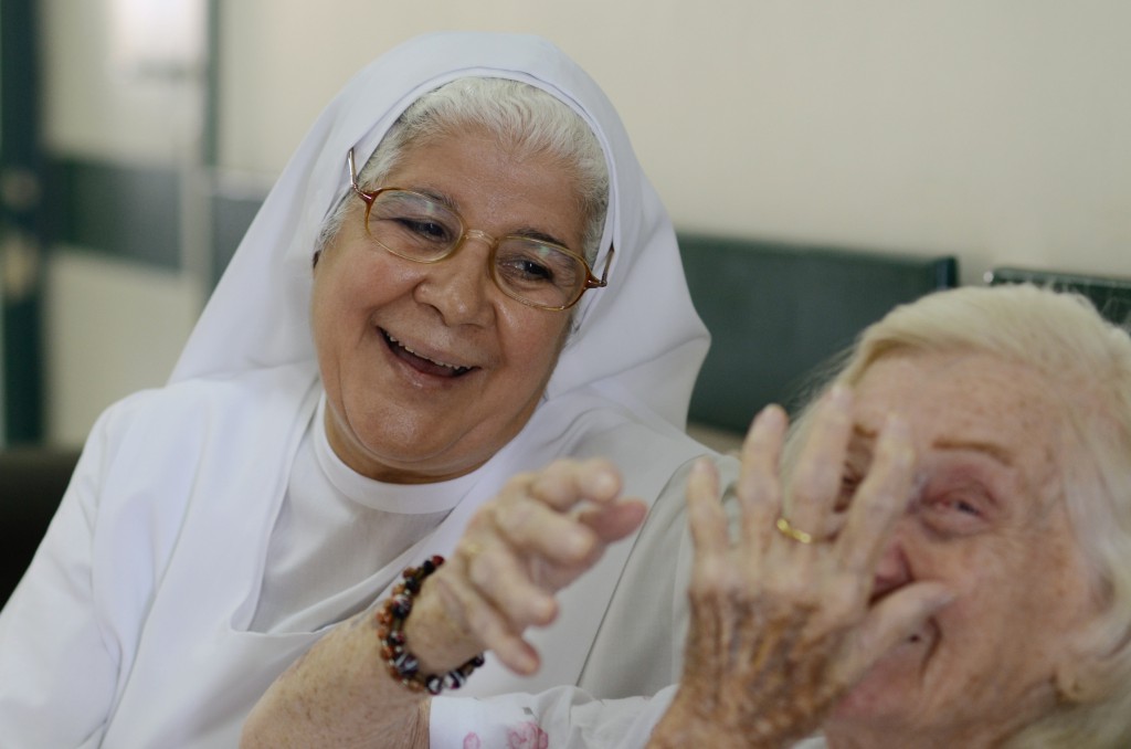 Sister Elizabeth Azim of the Franciscan Sisters of the Immaculate Heart of Mary talks with a patient at the Italian Hospital in Cairo Aug. 25. The Egyptian nun is a nurse in the hospital's surgical ward. PHOTO: CNS/Dana Smillie
