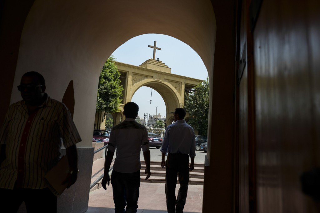 Men walk through an archway at the Coptic Orthodox Church of the Virgin Mary in the Maadi suburb of Cairo, Egypt, Aug. 25. The church sits on the left bank of the Nile River, which Egyptian Christians who pray and worship there are convinced transported Mary, Joseph and Jesus to safety from persecution back home. PHOTO: CNS/Dana Smillie 