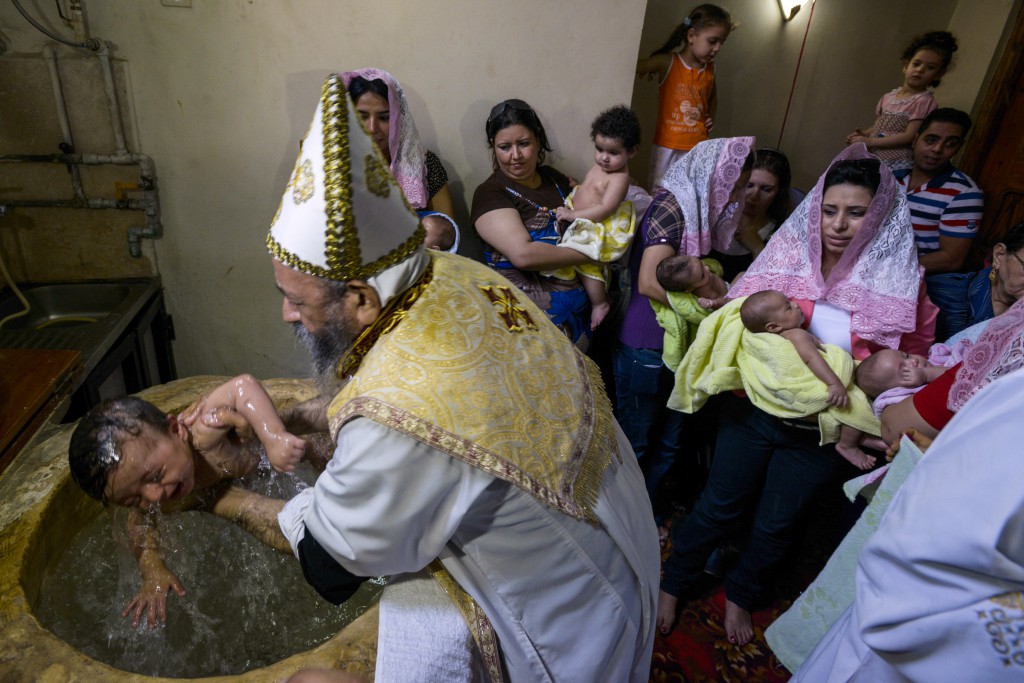 A priest on Aug. 25 baptizes a child at the Coptic Orthodox Church of the Virgin Mary in the Maadi suburb of Cairo, Egypt. PHOTO: CNS/Dana Smillie