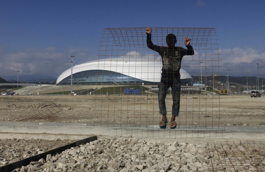 A worker lays down metal wire for a sidewalk on Aug. 19 in front of the Bolshoy Ice Dome in Sochi, Russia. PHOTO: CNS/Gary Hershorn, Reuters