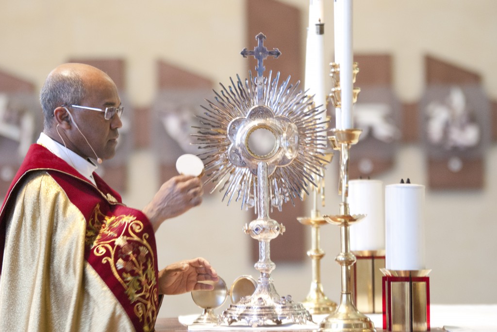 Perth vocations director Fr Jean-Noel Marie places the Blessed Sacrament in a monstrance at a Holy Hour for vocations, last Sunday. PHOTO: Robert Hiini