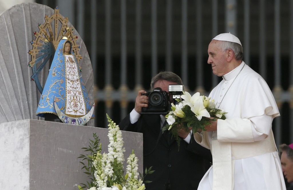 Pope Francis offers flowers to a statue of Our Lady of Lujan during his weekly audience in St Peter’s Square on May 8. PHOTO: Stefano Rellandini, Reuters, cns