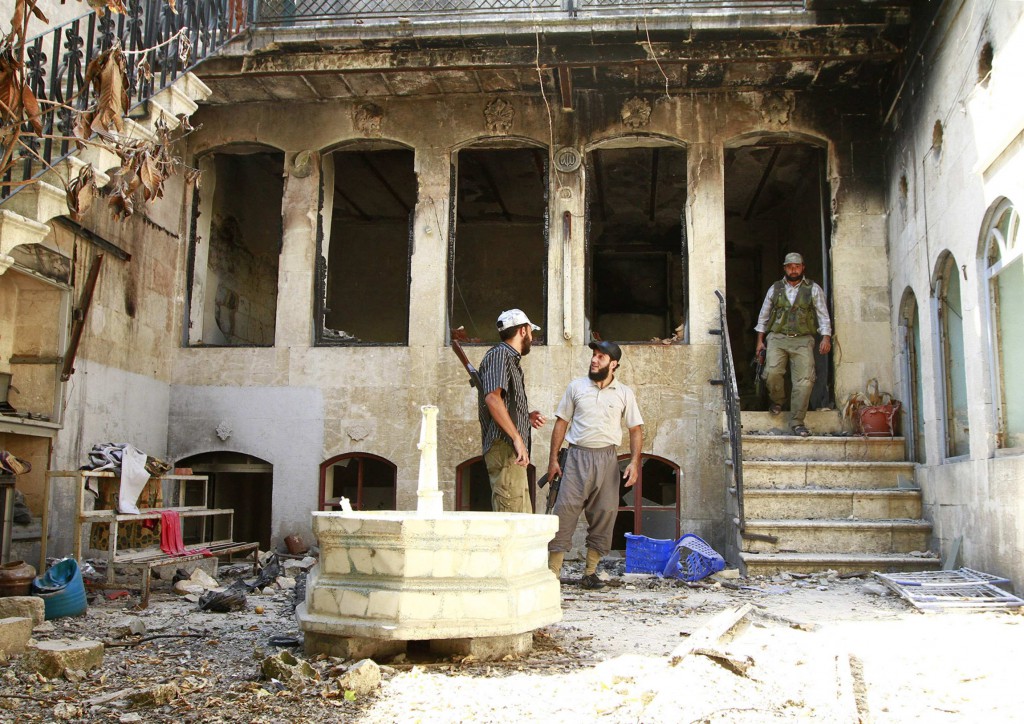 Free Syrian Army fighters chat as they stand near a damaged building in Aleppo Sept. 3. Two leaders of the U.S. Conference of Catholic Bishops urged U.S. Catholics to take up Pope Francis' call to fast and pray for peace in Syria, the Middle East and the world Sept. 7. PHOTO: CNS/Hamid Khatib, Reuters