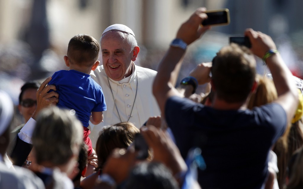 Pope Francis greets a child as he arrives to lead his weekly audience on Sept. 4 in St. Peter's Square at the Vatican. PHOTO: CNS/Tony Gentile, Reuters