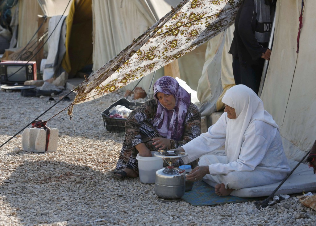 Syrian refugees cook outside a tent at the Majdal Anjar refugee camp in Bekaa Valley near the Syrian border in eastern Lebanon. Lebanon, with its population of about 3.5 million people, has received more than 1.5 million Syrian refugees, the largest amount of any country in the region. PHOTO: CNS/Jamal Saidi, Reuters