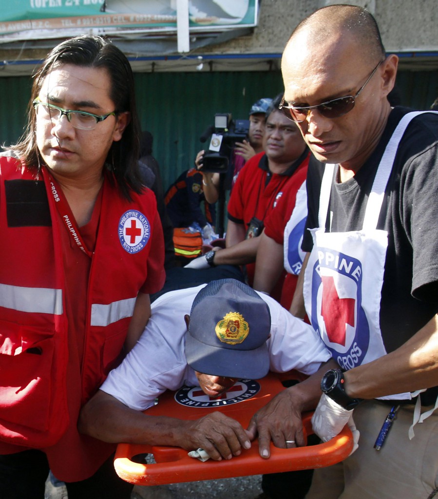 Philippine Red Cross personnel carry a wounded hostage rescued from rebels belonging to the Moro Islamic l Liberation Front in Zamboanga, Philippines Sept. 13. Bishops in southern Philippines have condemned the rebels' use of hostages as human shields in gunfights with government troops. PHOTO: CNS/Erik De Castro, Reuters