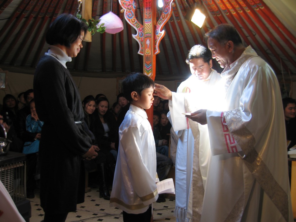 Bishop Wenceslao Padilla of Ulan Bator, the Mongolian capital, confirms a boy named George at Easter in 2008 in a tent that serves as Good Shepherd Church. Father Ronald Magbanua, the pastor, assists while George's sponsor looks on. Mongolians use only a first name. PHOTO: CNS