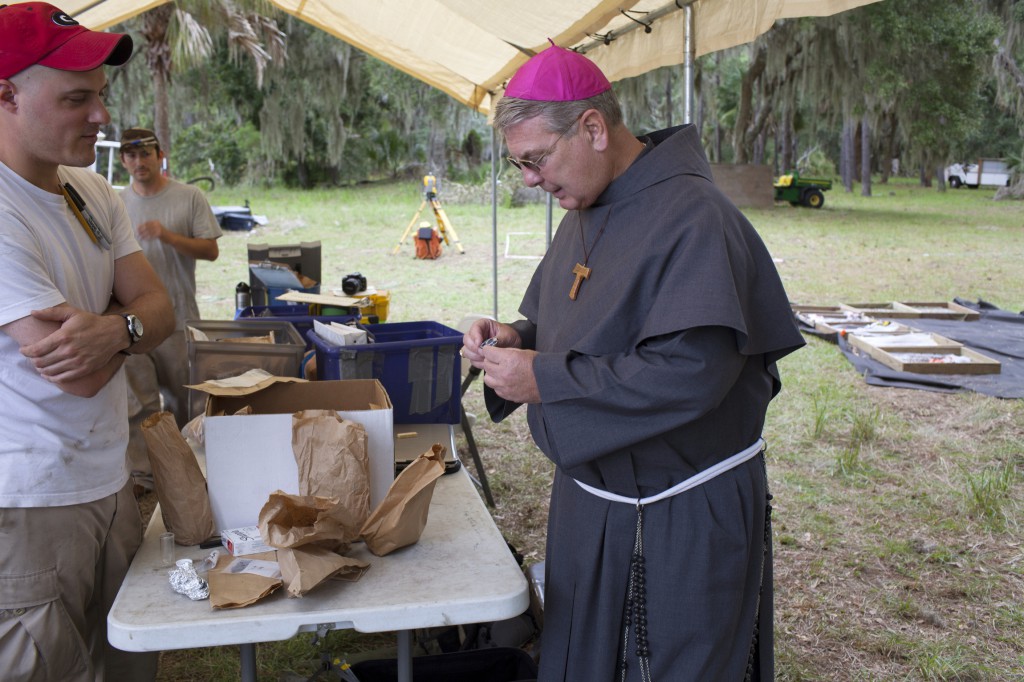 Bishop Gregory J. Hartmayer of Savannah looks over an artifacts found on St. Catherines Island in Georgia Oct. 14. Looking on is archaeologist Matthew Napolitano of the American Museum of Natural History. Earlier in the day, the bishop celebrated Mass at the island's historic mission site. The mission dates back to the 1570s and has been the subject of study by archaeologists for nearly three decades. Scientists on the island continue to excavate with a sense of urgency as erosion from rising sea levels threaten the remains of a vanished American Indian community. PHOTO: CNS/Tom Phelan
